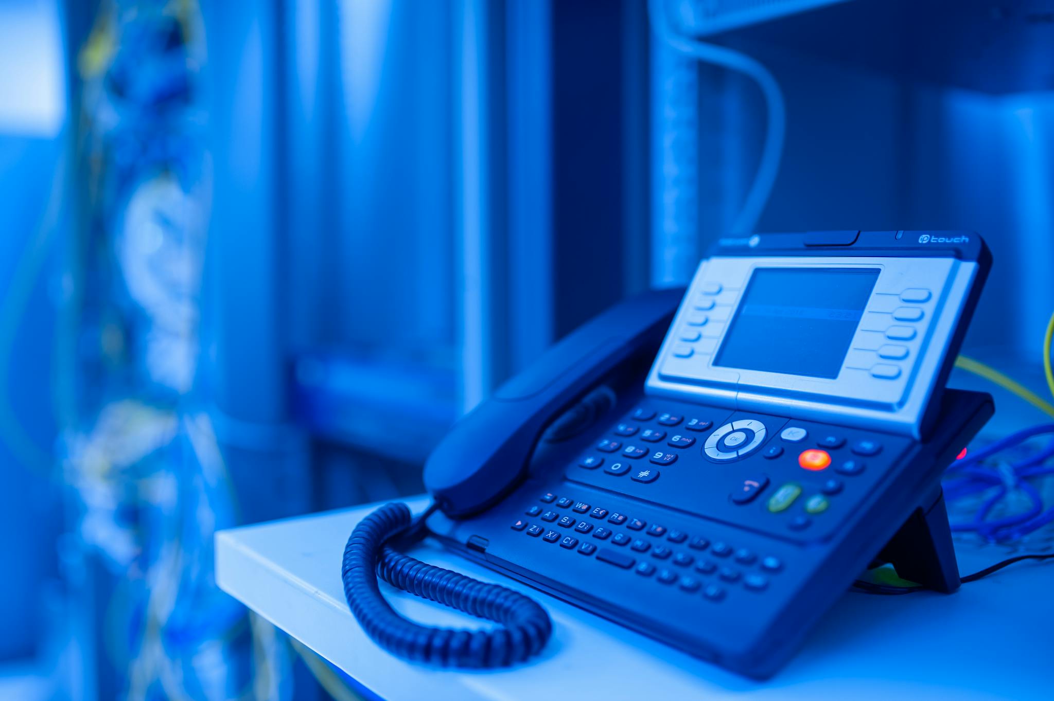 close-up-of-a-modern-office-phone-in-blue-lighting.-ideal-for-tech-and-business-themes.-17636234-2048x1363.jpg